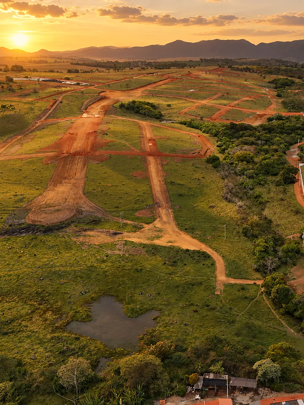 Foto aérea das ruas abertas do loteamento ao pôr do sol